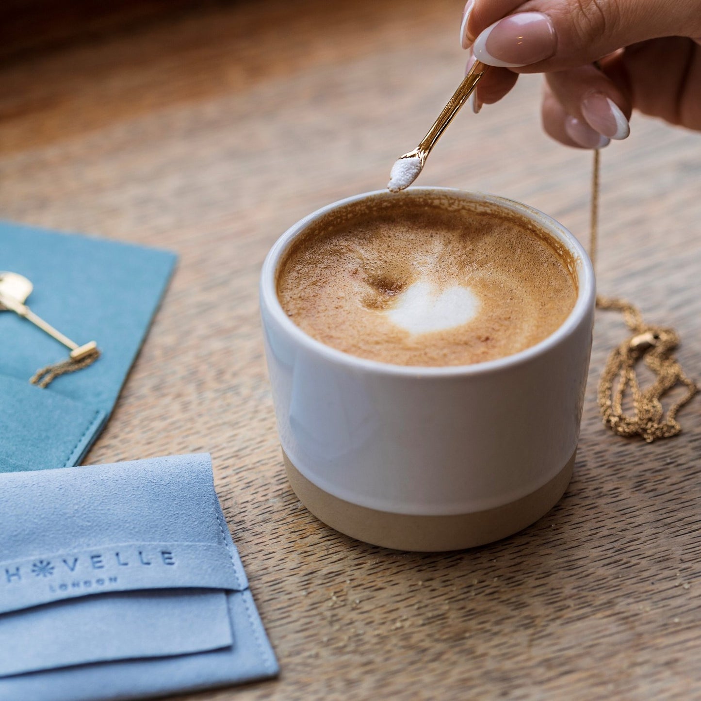 lifestyle shot of The Anglesea Arm Gold – secret spoon necklace with coffee