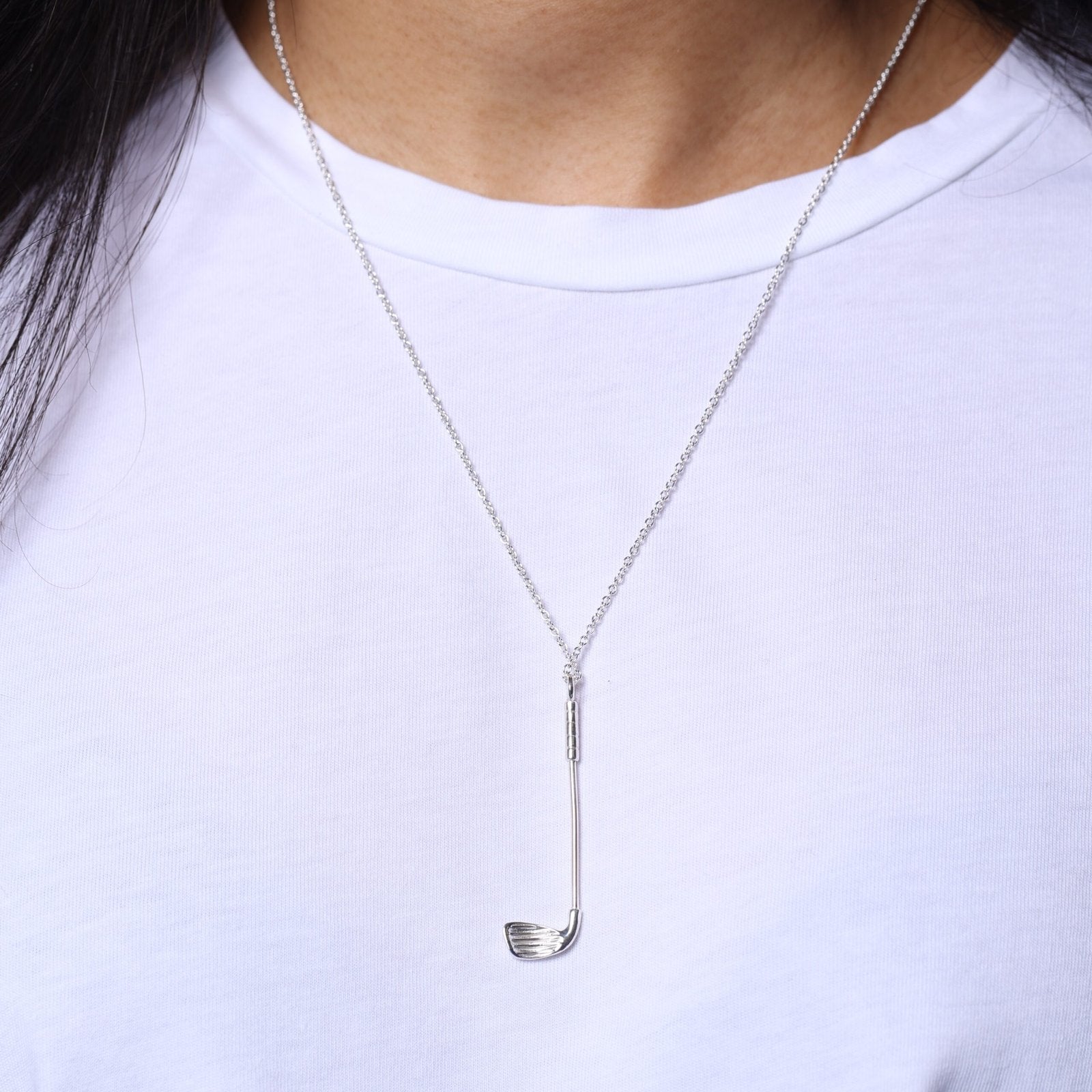 model in white tee wearing Who's Your Caddy silver golf club necklace