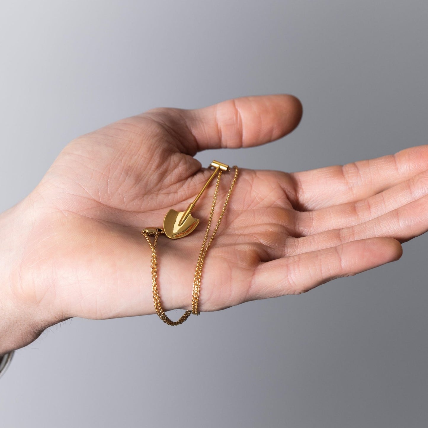 gold spade locket necklace held in hand – Spade In Chelsea
